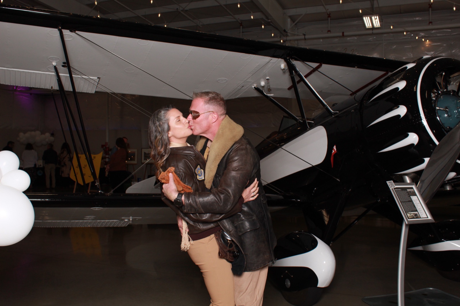 Guests at a benefit auction in an aviation museum hangar
