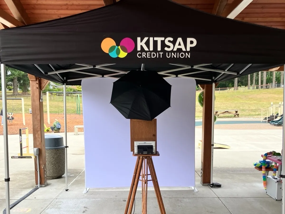 The booth set up under a branded tent at an outdoor corporate event
